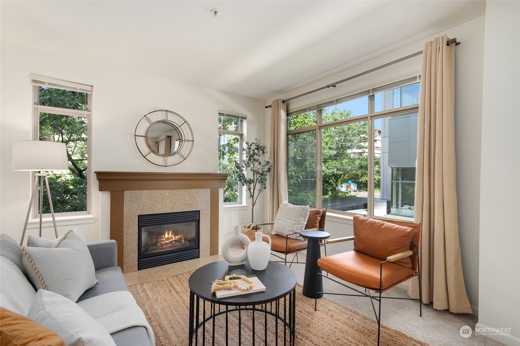 a living room with furniture a fireplace and a large window