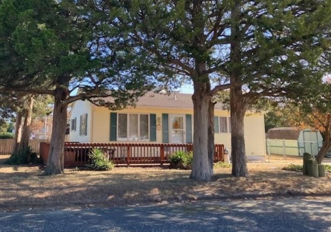 a front view of a house with a tree