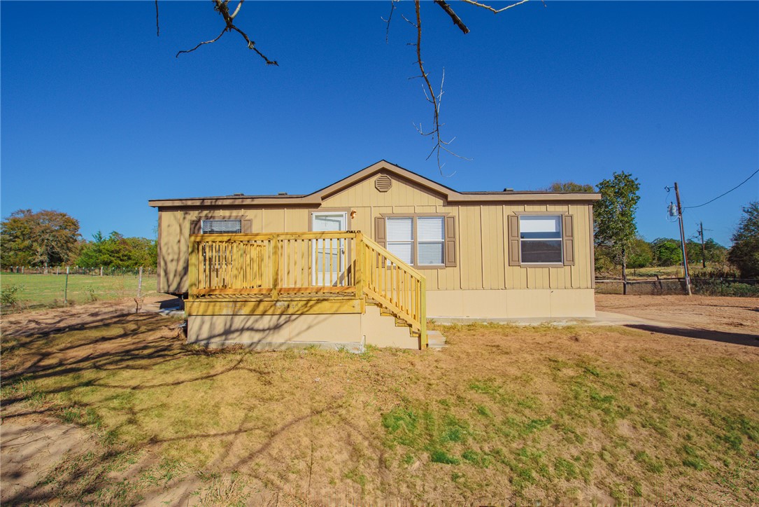 Back of house featuring a deck and a yard