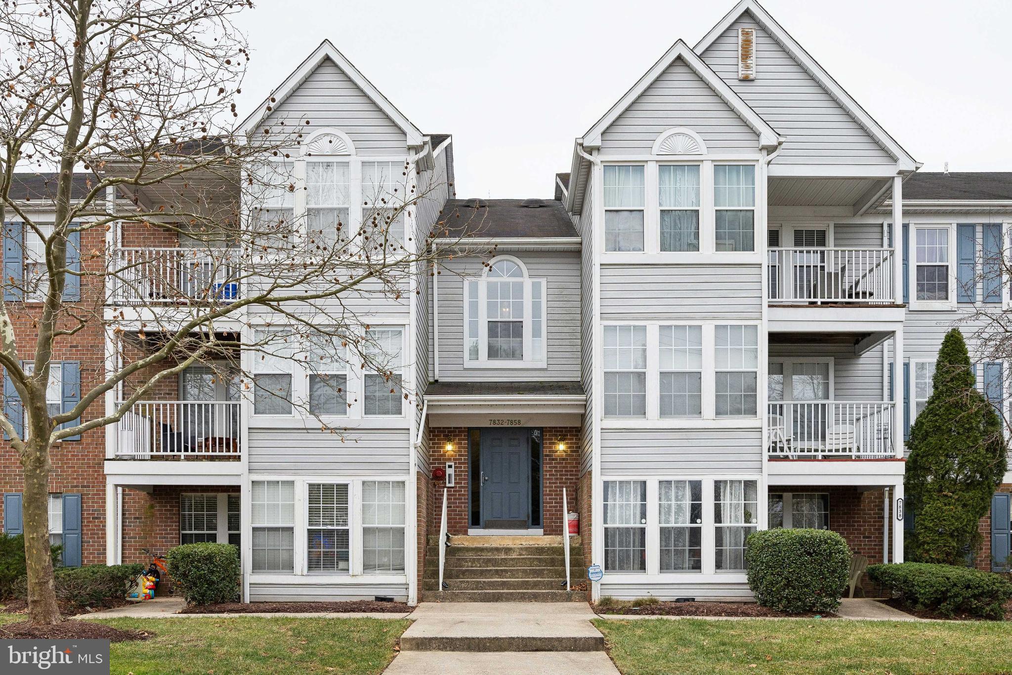 a front view of a residential apartment building with a yard