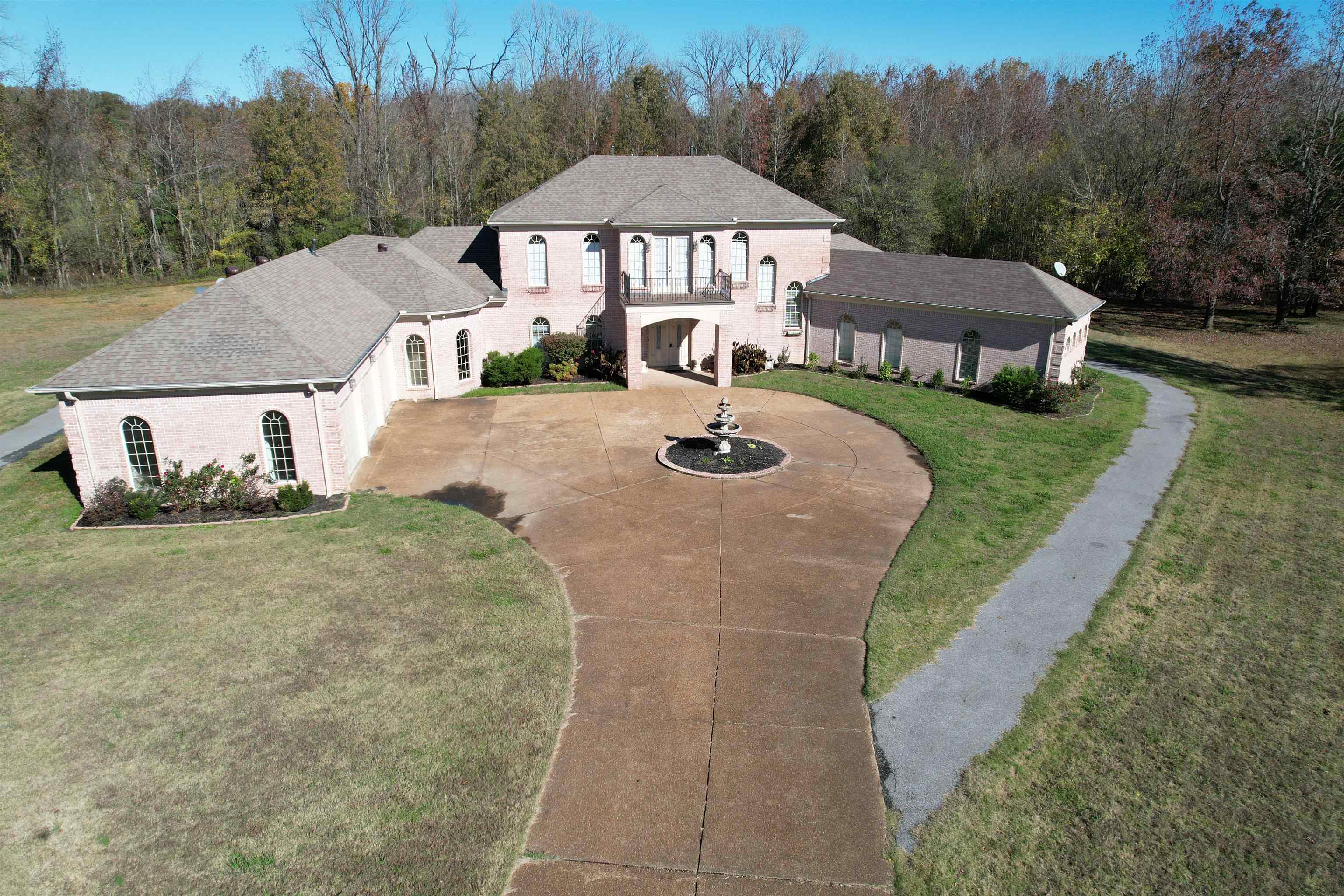 View of front of home with a balcony and a front lawn