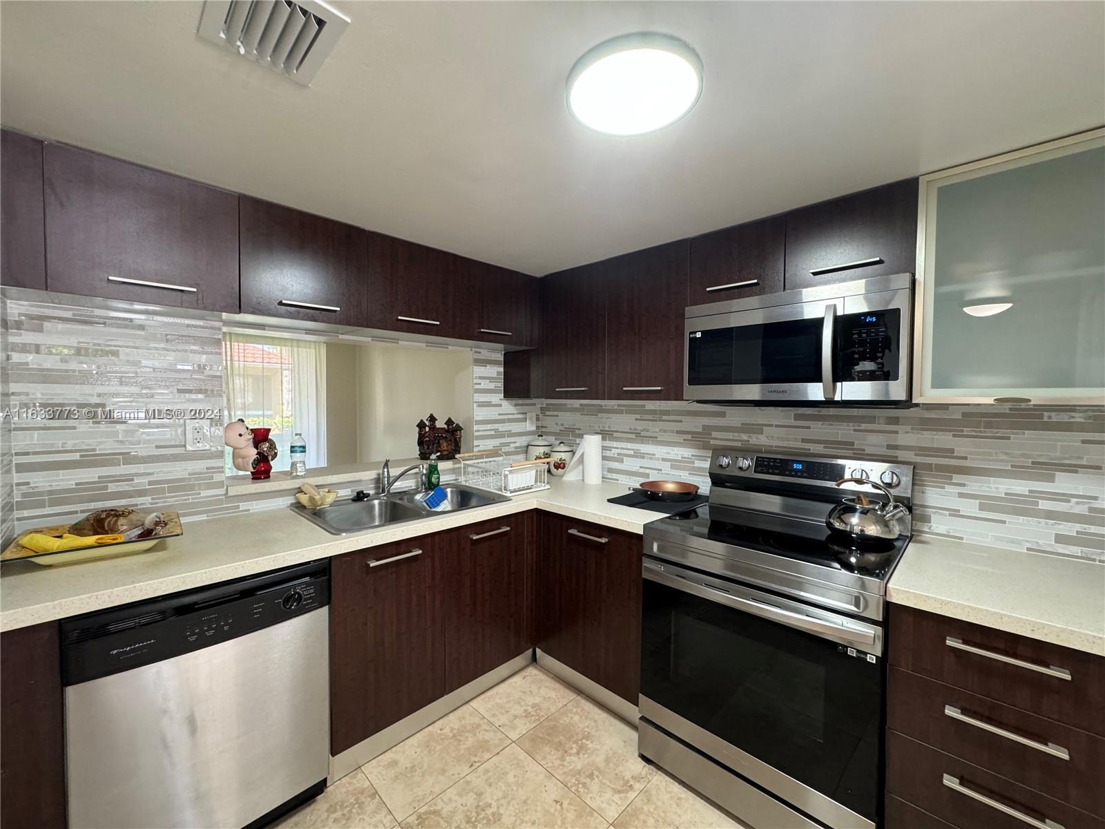 a kitchen with a sink stove top oven and cabinets