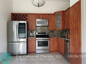 a kitchen with granite countertop a stove and a refrigerator