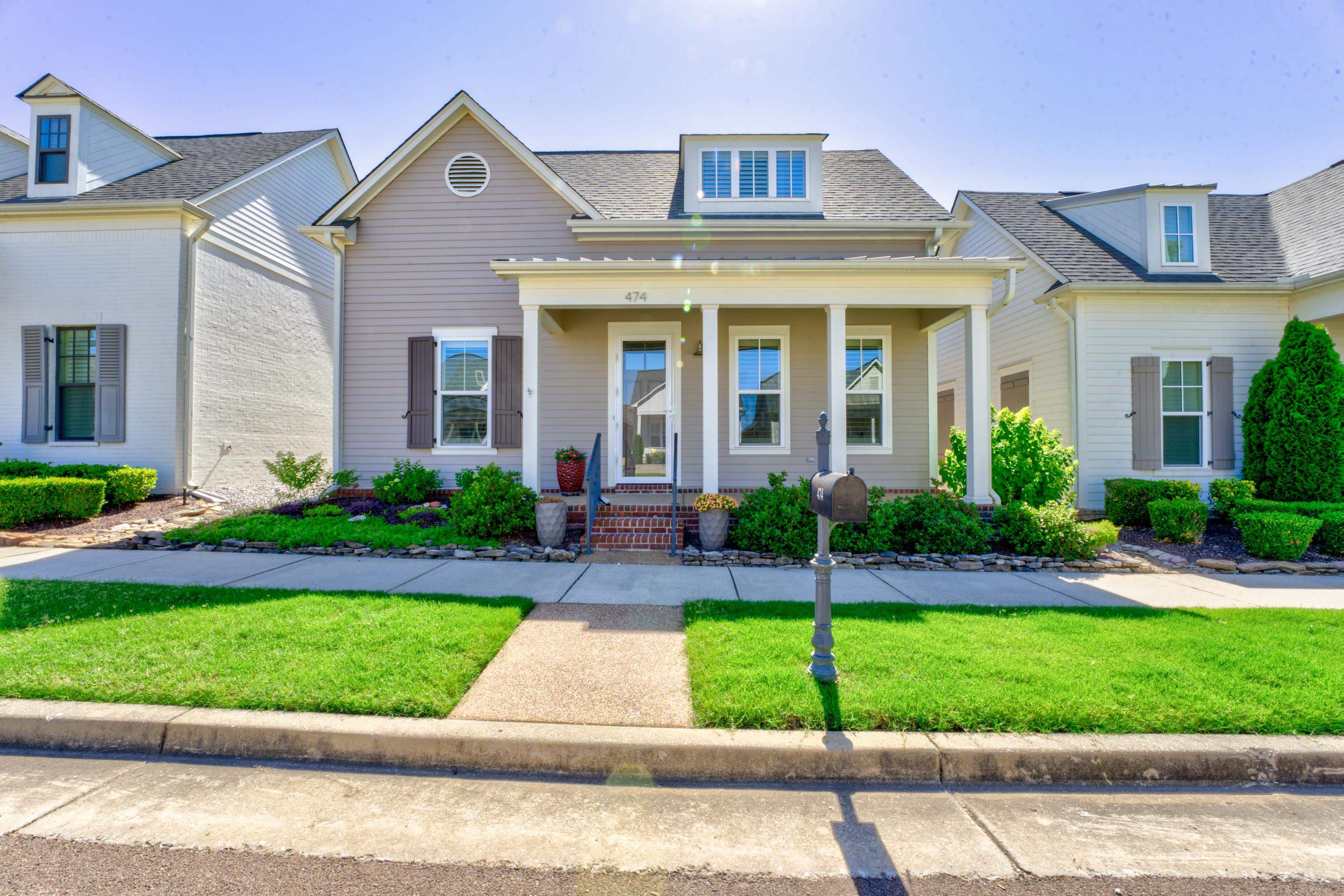 a front view of a house with a garden and plants