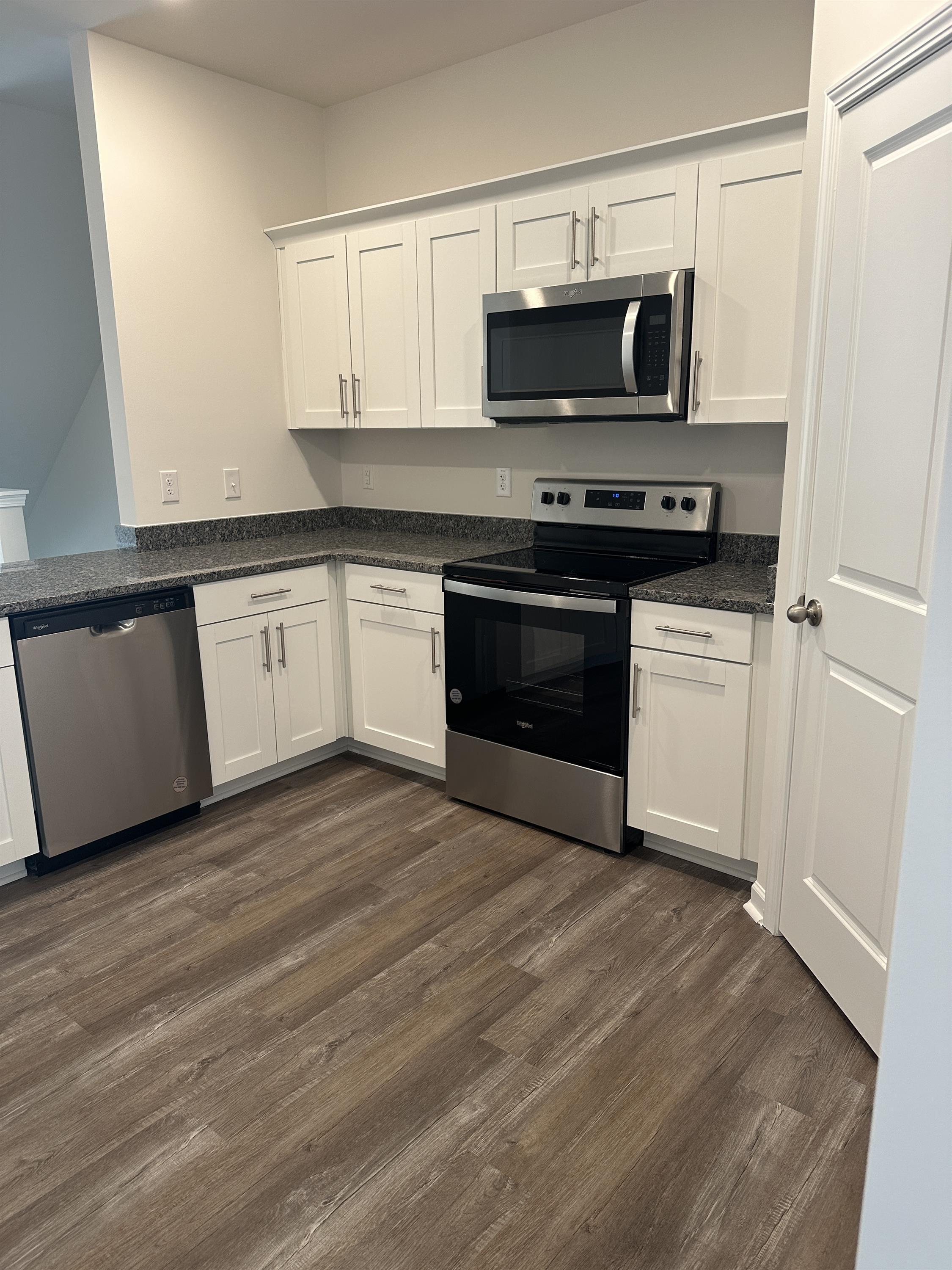 a kitchen with granite countertop a stove and a microwave