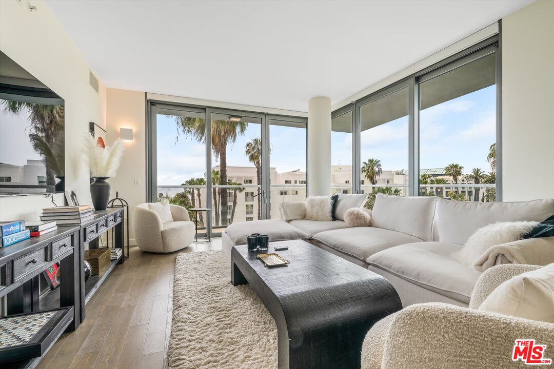 a living room with furniture and a floor to ceiling window