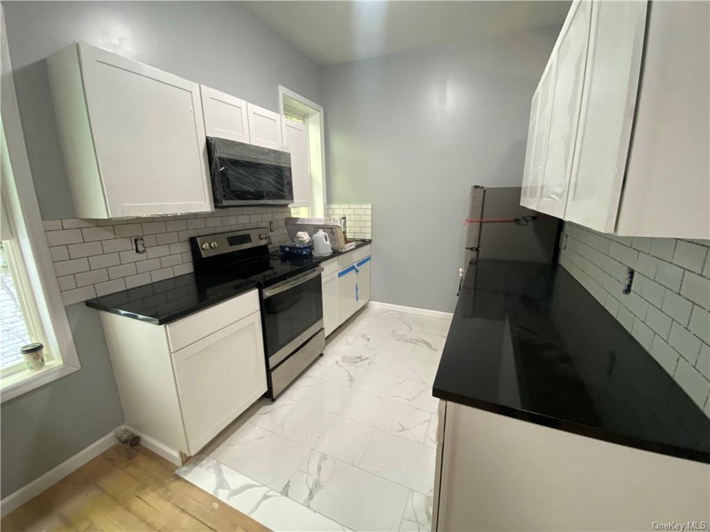 a kitchen with stainless steel appliances a stove microwave and sink