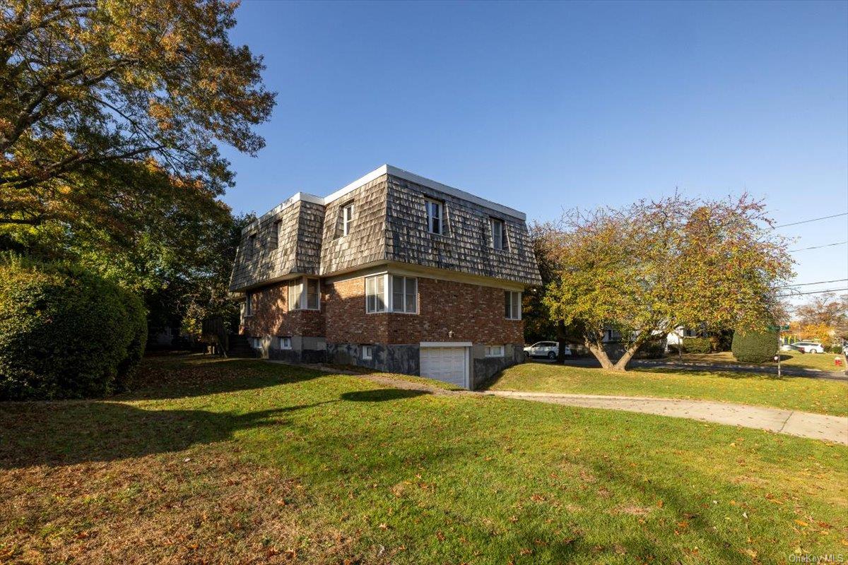 a view of a big house with a big yard and large trees