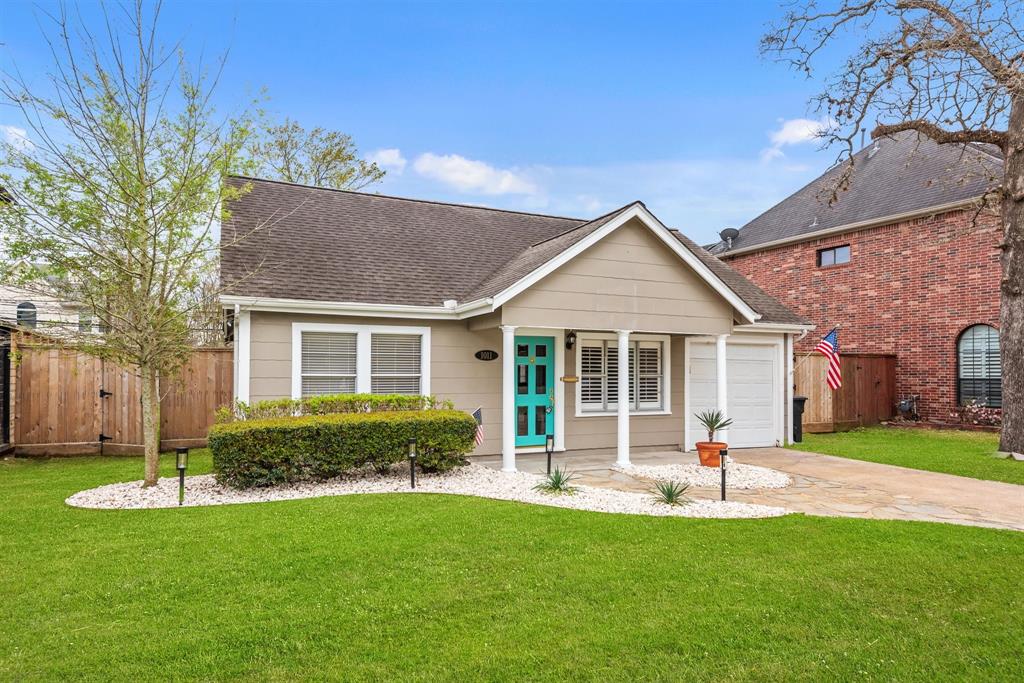 a front view of a house with a yard and green space