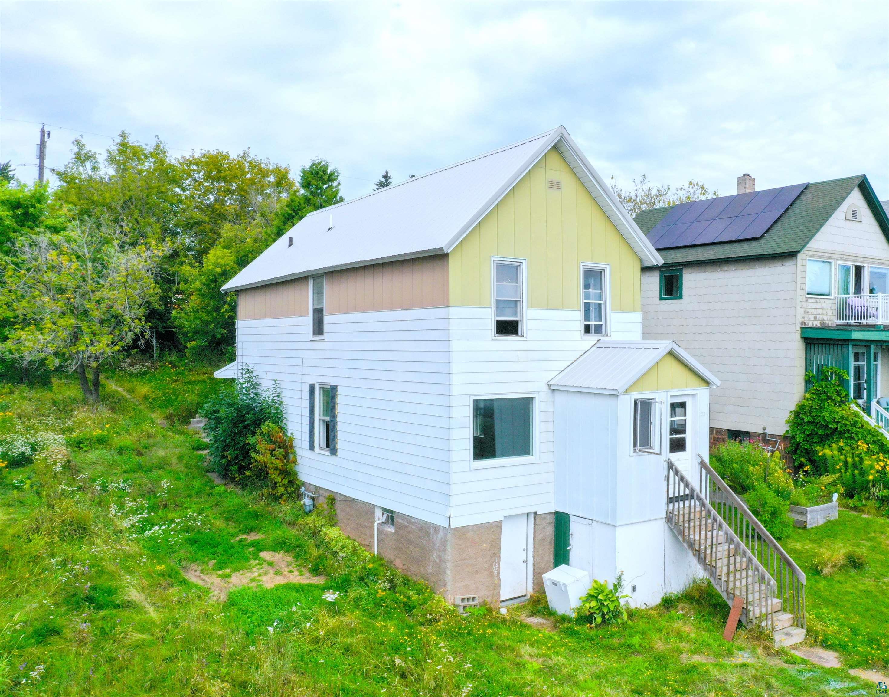 View of property exterior with solar panels and a balcony