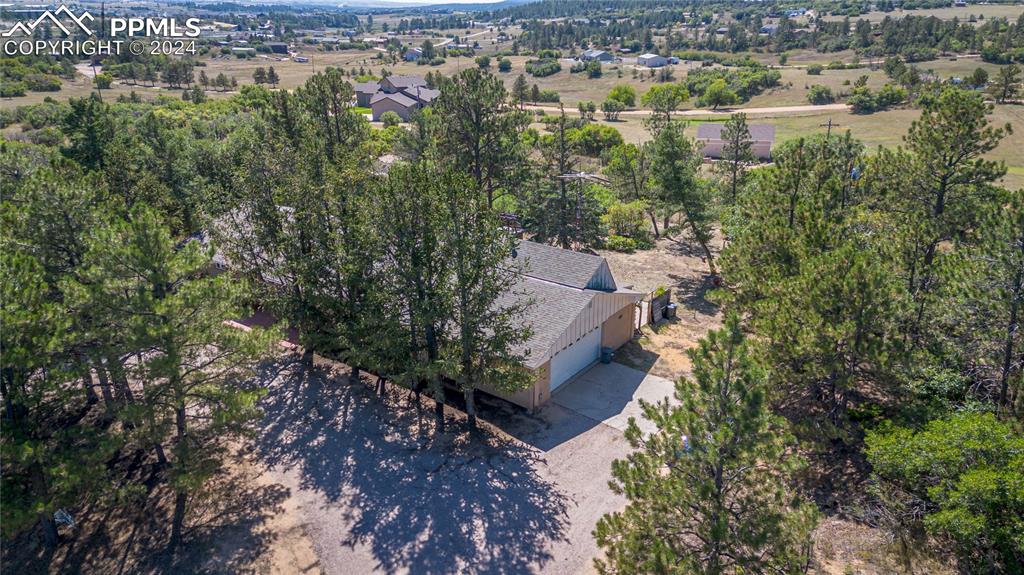 an aerial view of house with yard and mountain view in back