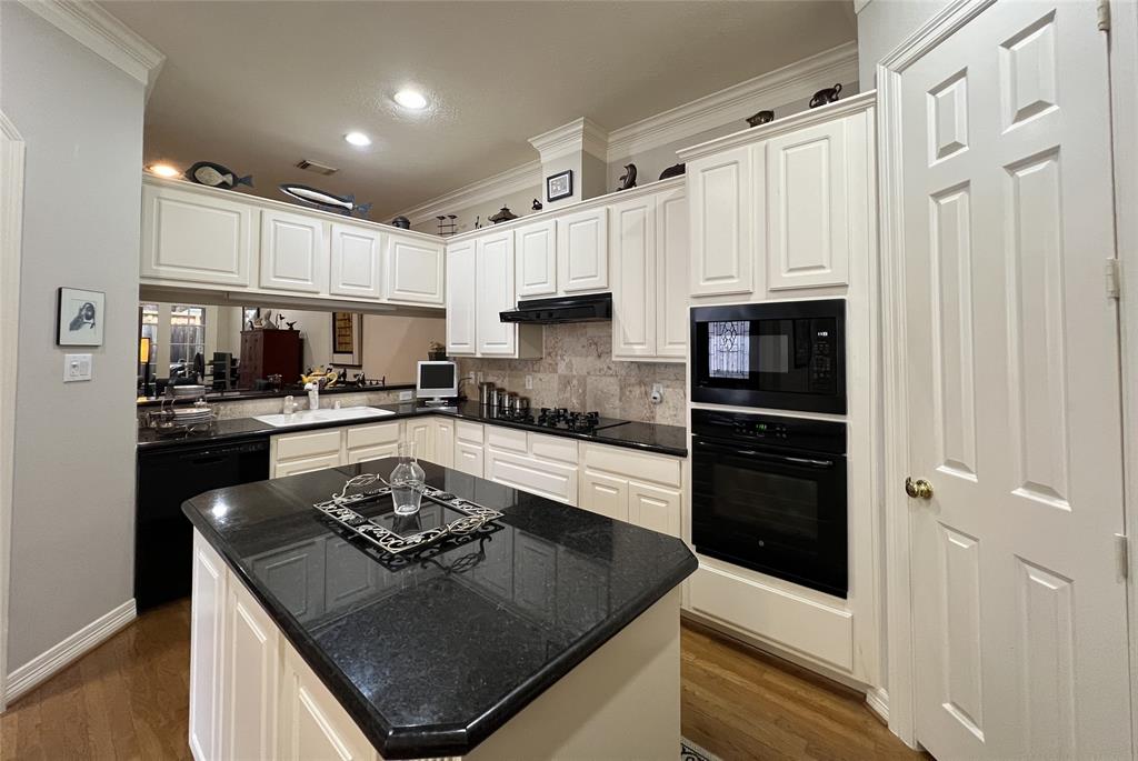 a kitchen with granite countertop a sink stove and refrigerator