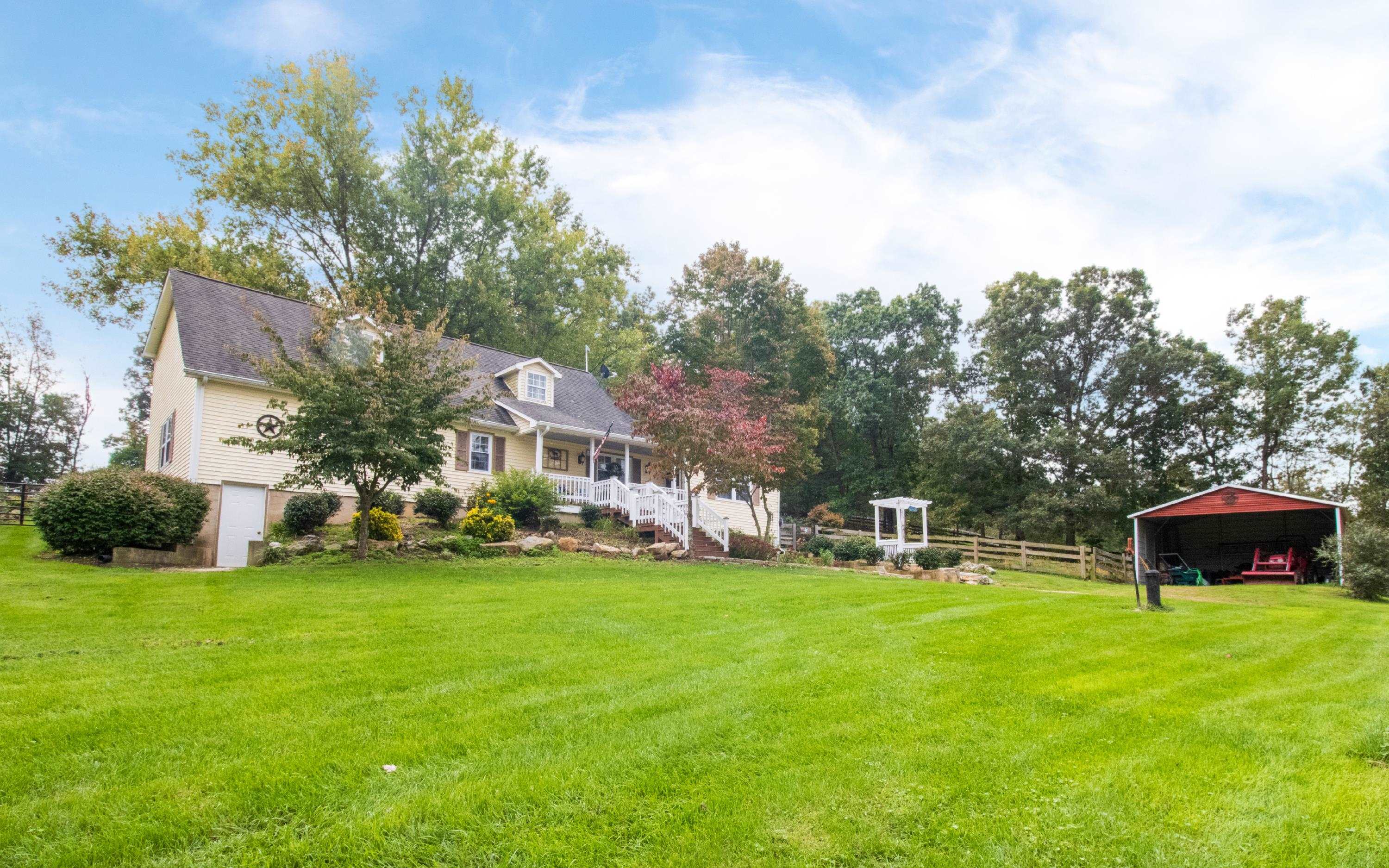 a view of a house with a yard and sitting area