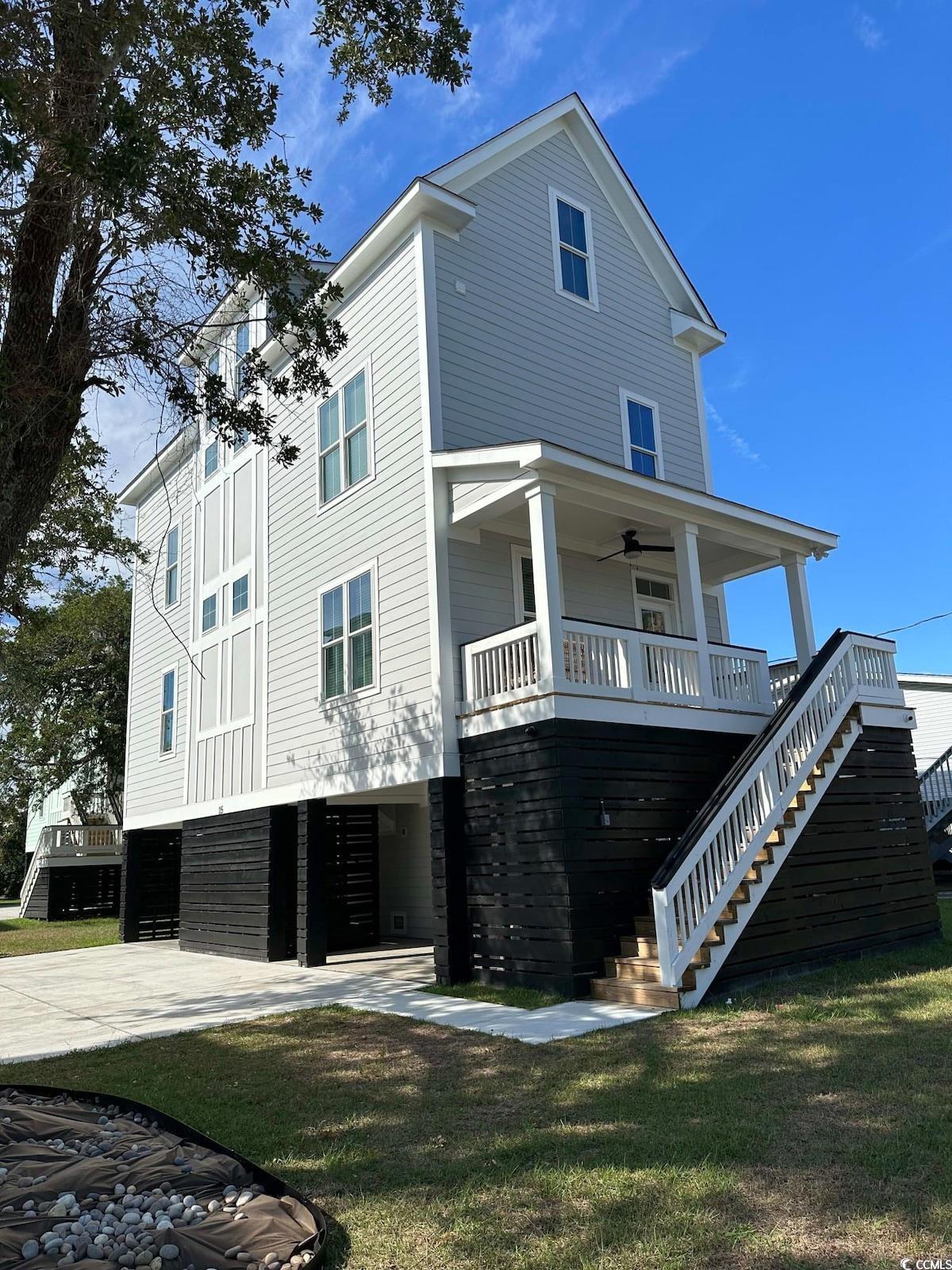 Back of property featuring ceiling fan, a lawn, an