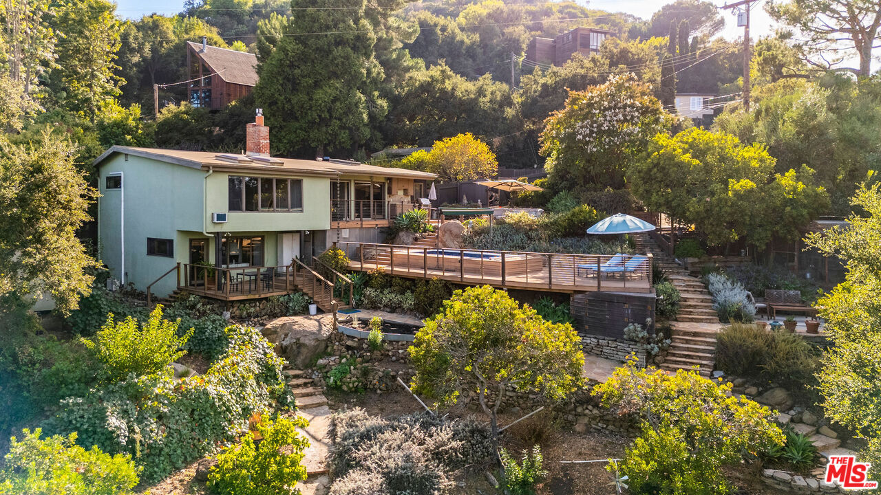 a aerial view of a house with swimming pool and large trees