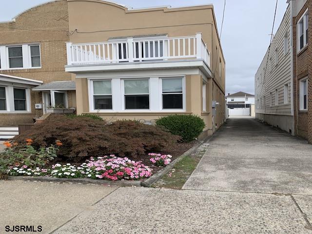 a view of a house with a small yard and flower plants