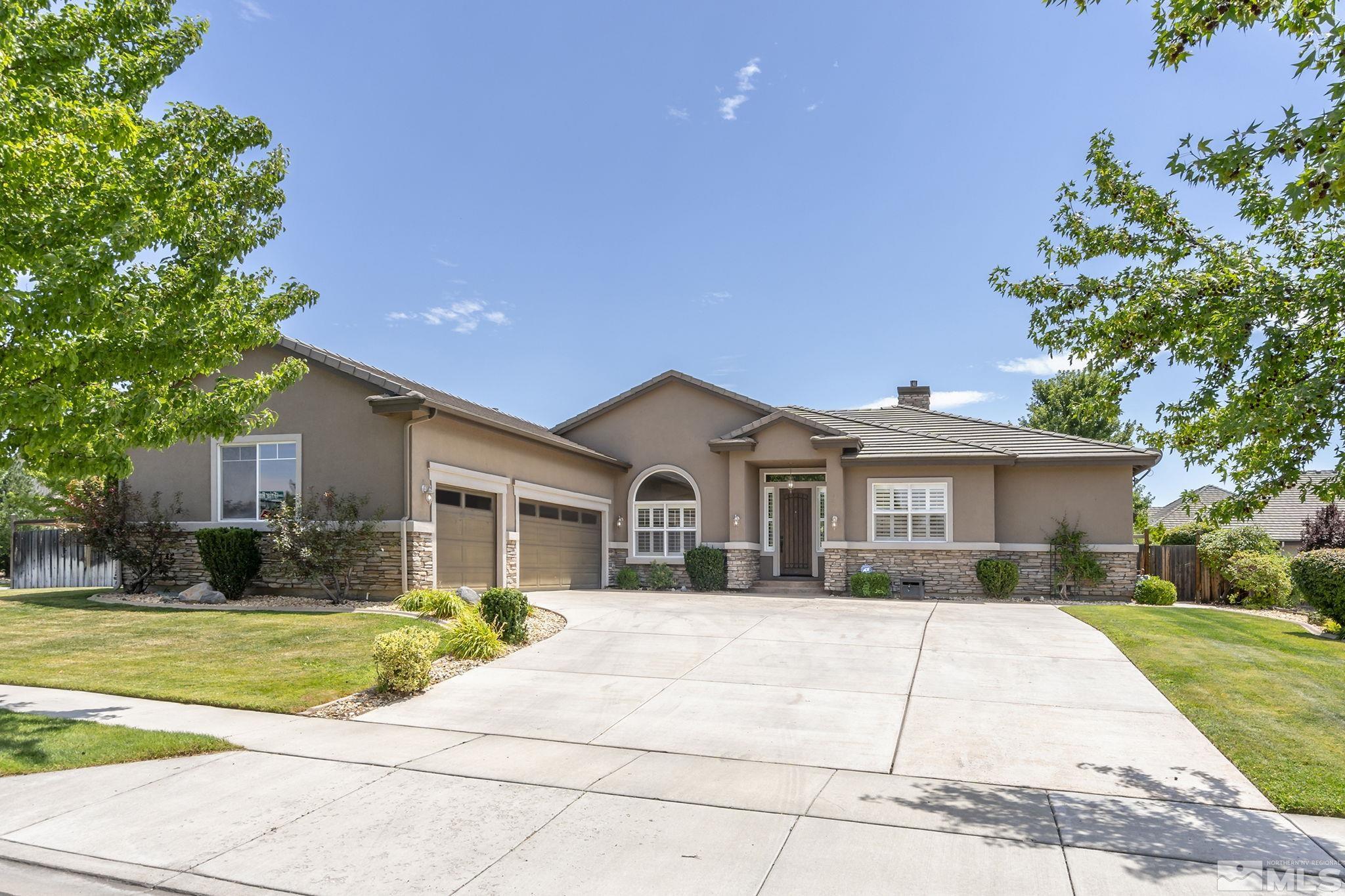 a front view of a house with a yard and trees