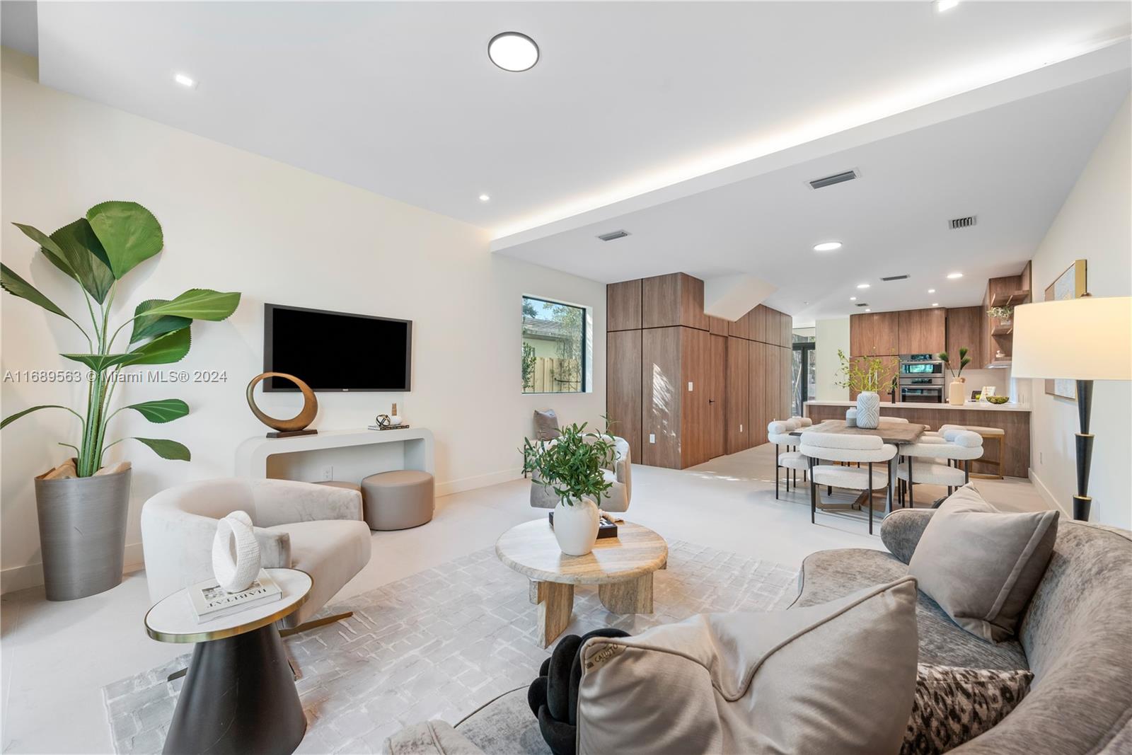 a living room with furniture and view of kitchen