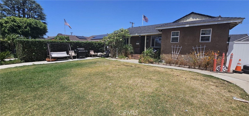 a view of a house with a yard and sitting area