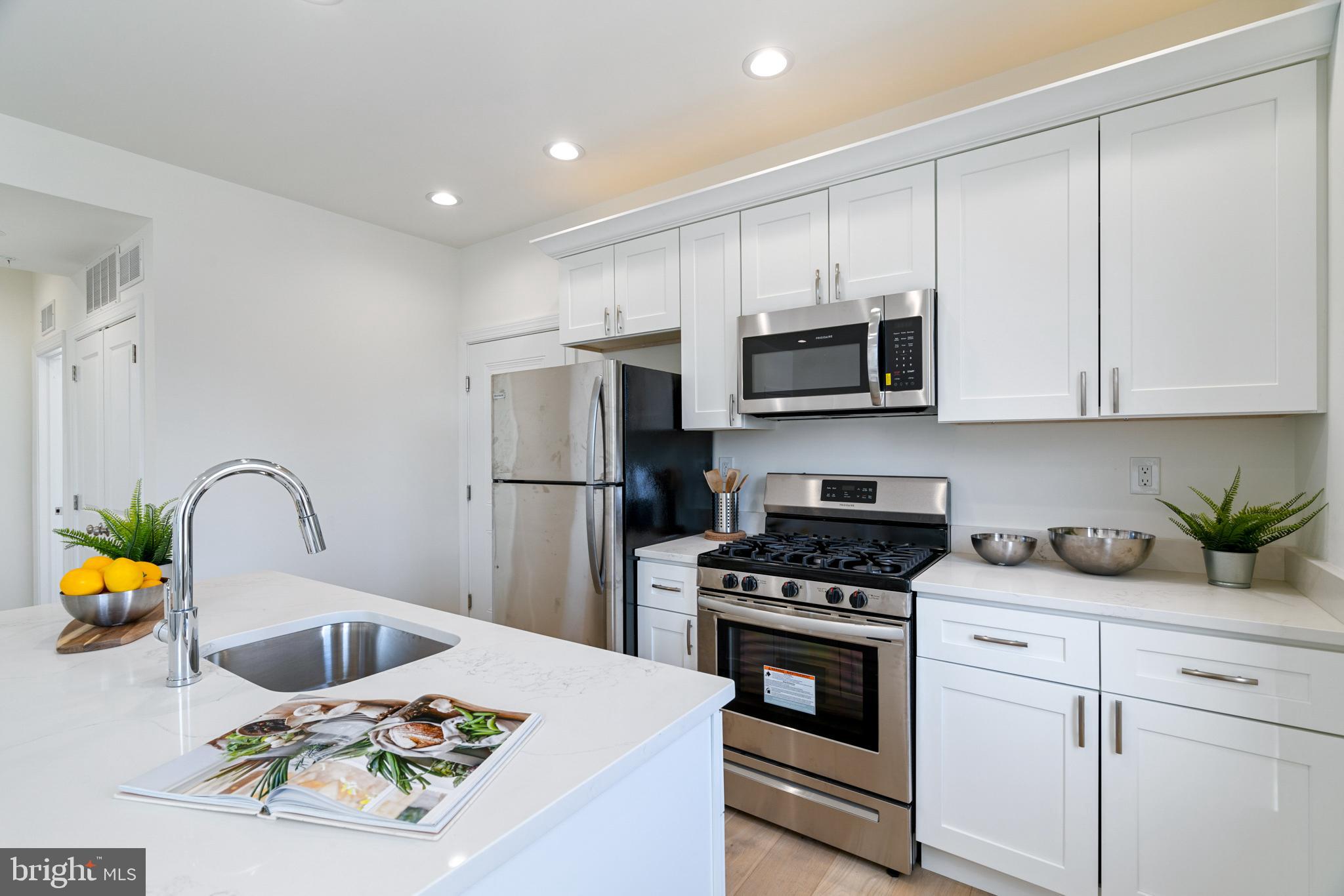 a kitchen with appliances a sink and cabinets