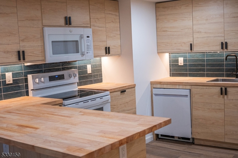 a kitchen with stainless steel appliances wooden floor and a counter top space