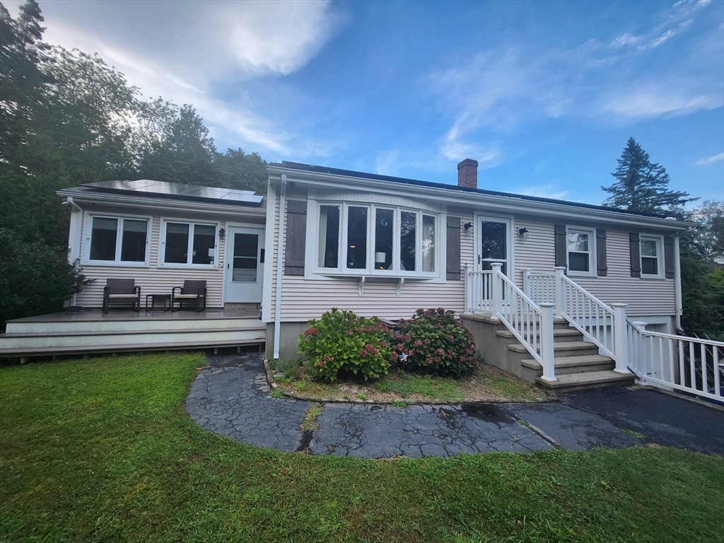 a front view of a house with yard and green space