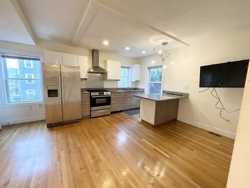 a kitchen with stainless steel appliances a refrigerator and a stove top oven