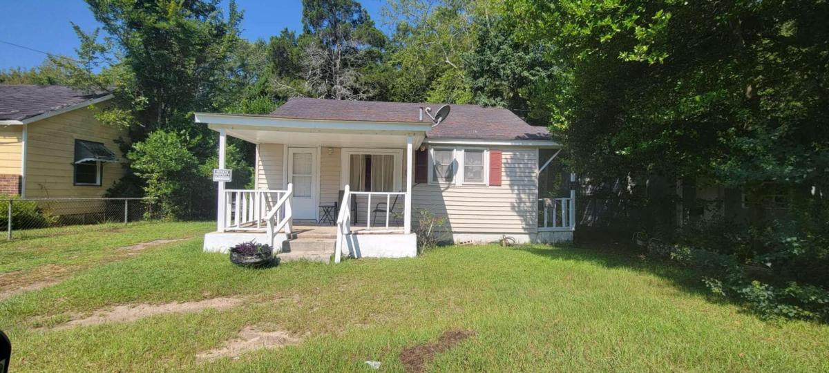 a view of a small house with backyard