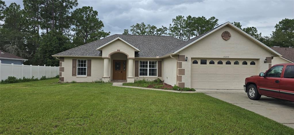 a front view of a house with a garden and yard