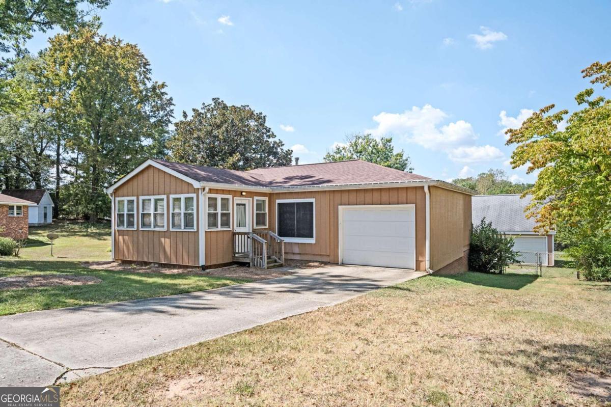 a front view of a house with a yard and wooden fence