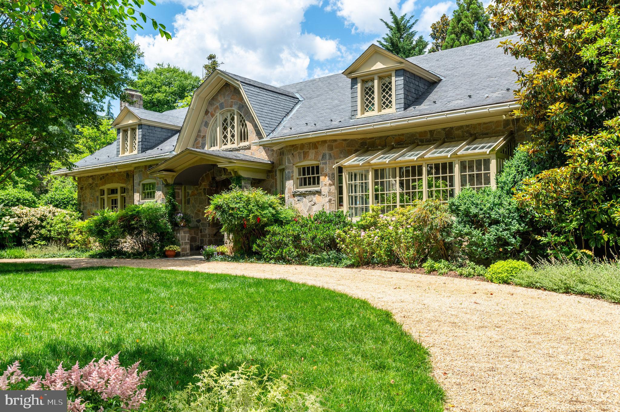 a view of a white house with a big yard and potted plants