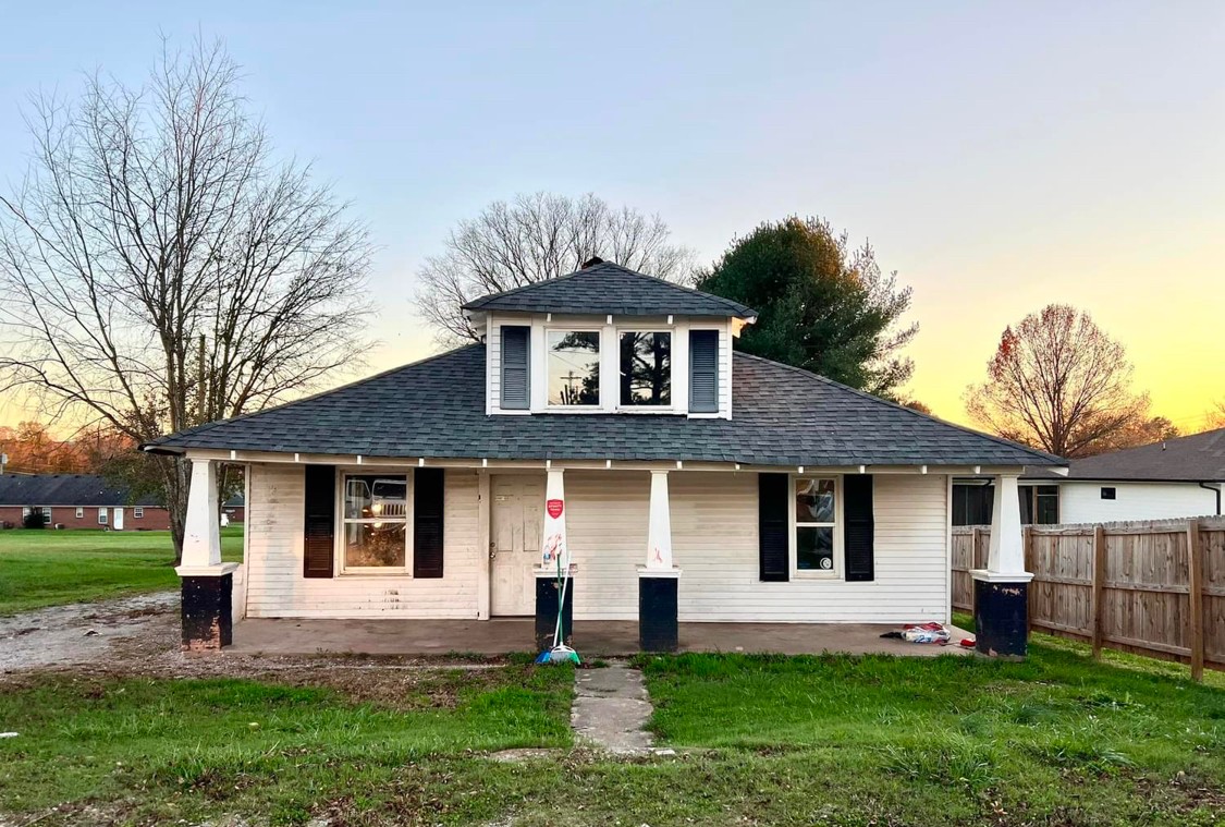 a front view of a house with a yard and trees