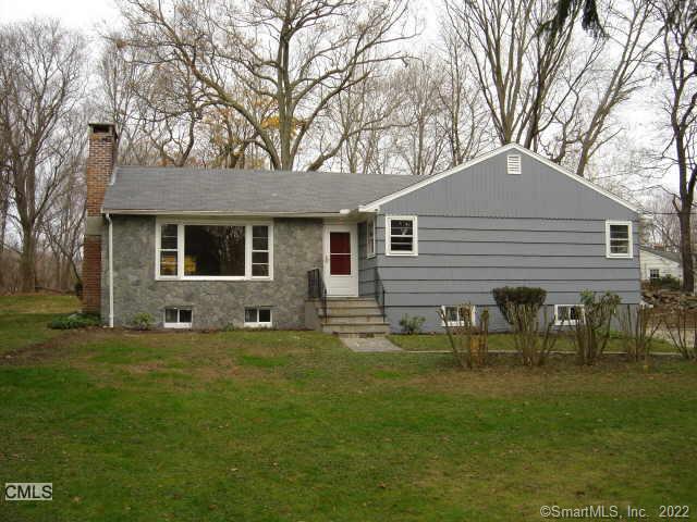 a front view of house with yard and trees