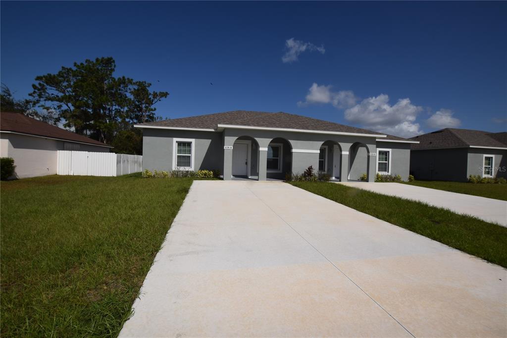 a view of house with a yard