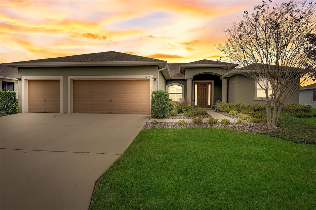 a front view of a house with a garden and yard