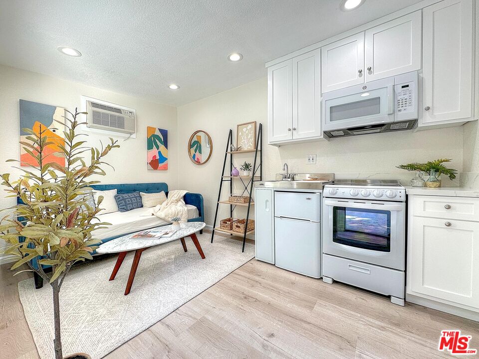 a living room with stainless steel appliances kitchen island furniture and wooden floor