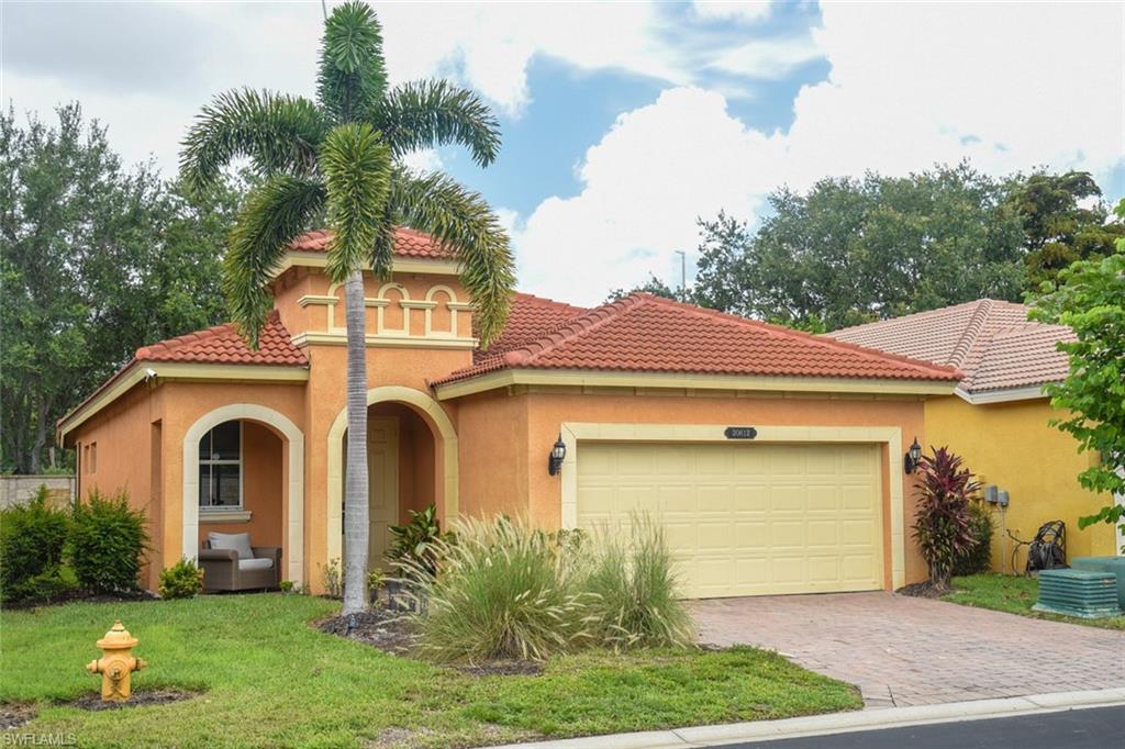 Mediterranean / spanish-style house with a garage and a front lawn