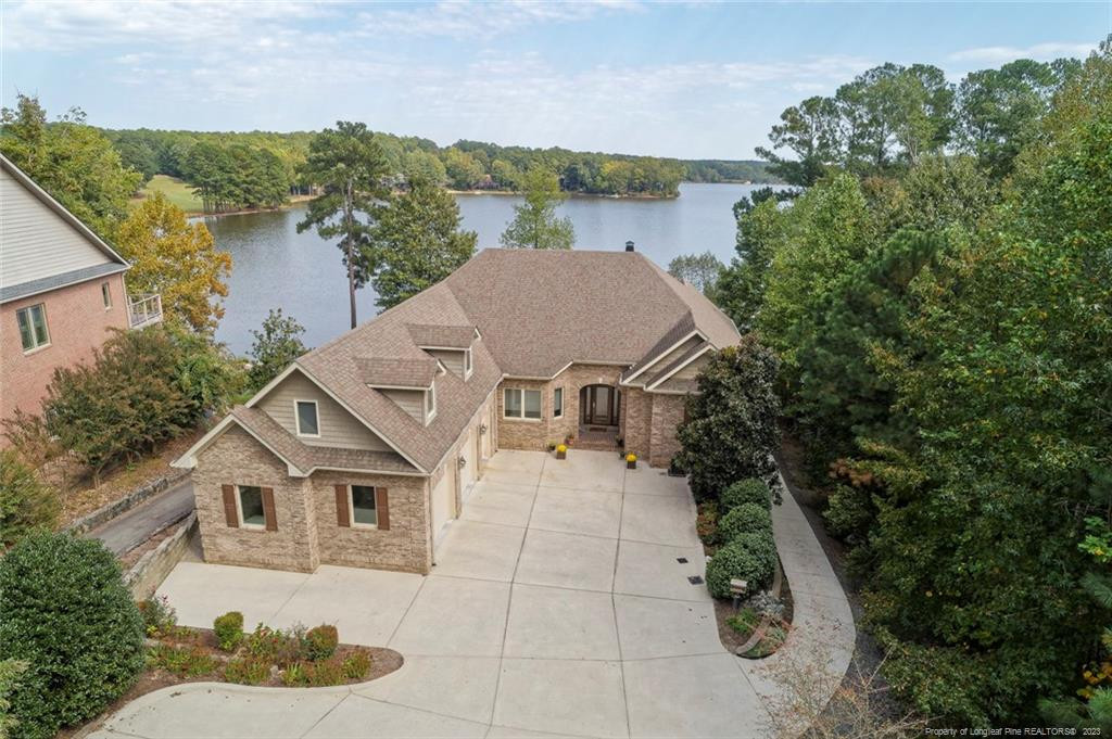 an aerial view of a house with a yard and lake view