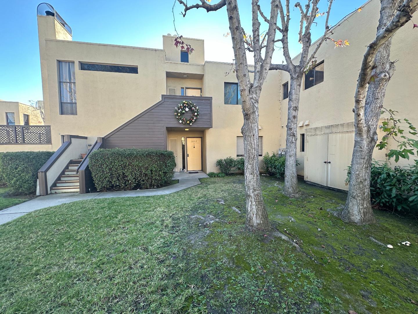 a view of a big house with a big yard and large tree