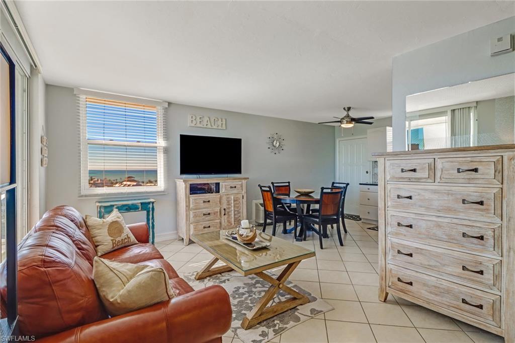 a living room with furniture a flat screen tv and a window