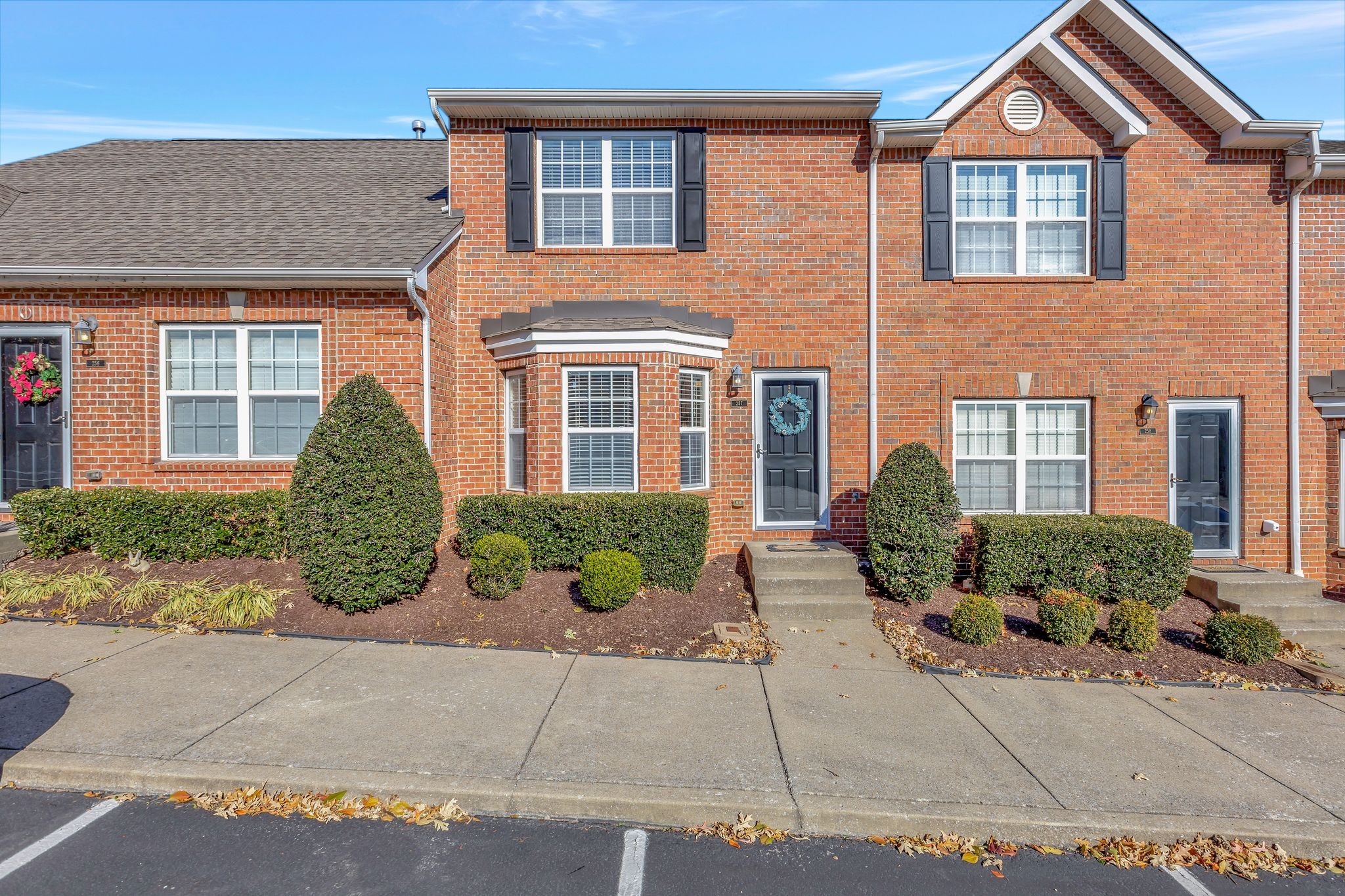 front view of a brick house with a yard