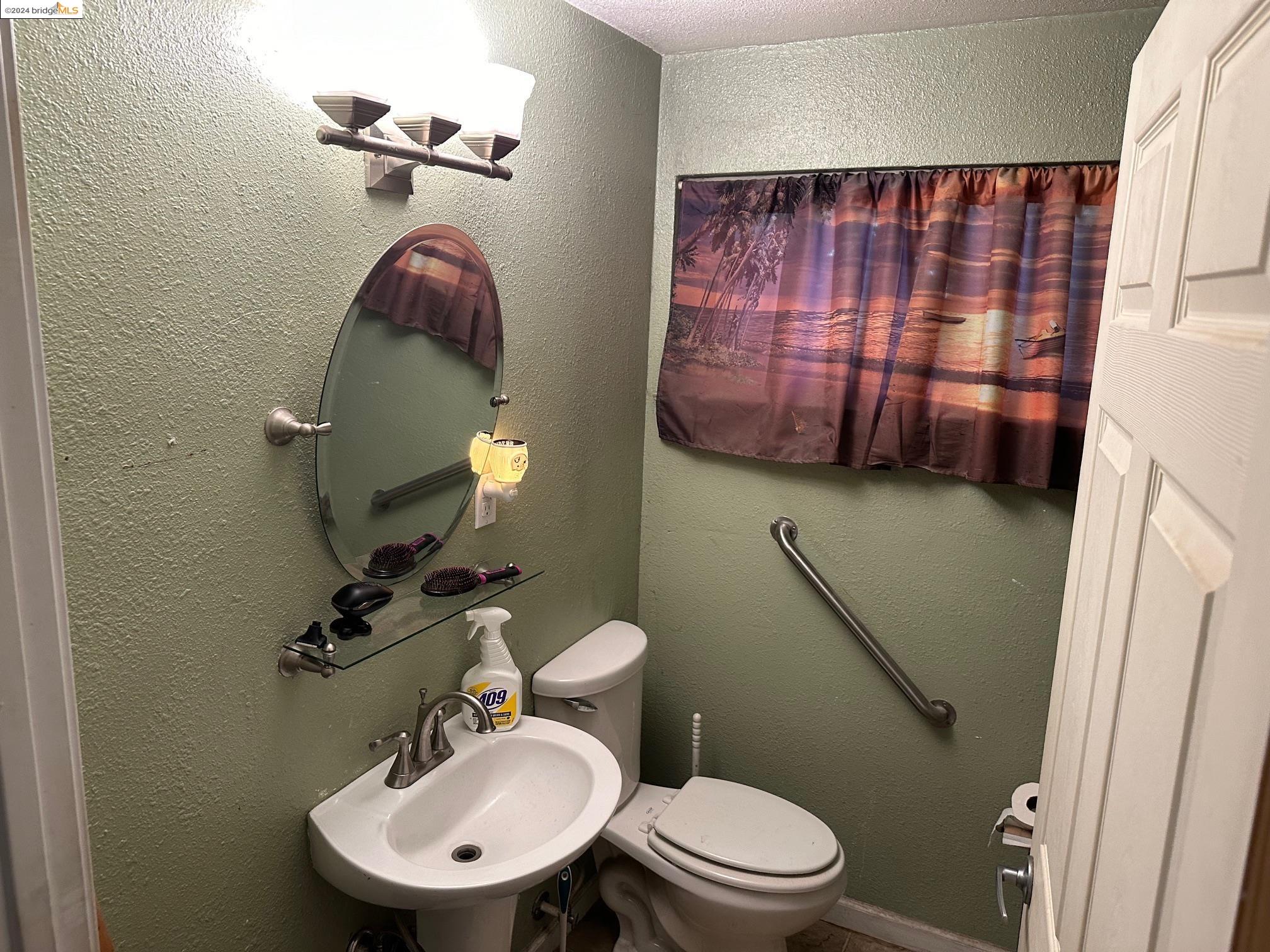 a bathroom with a toilet a sink and mirror