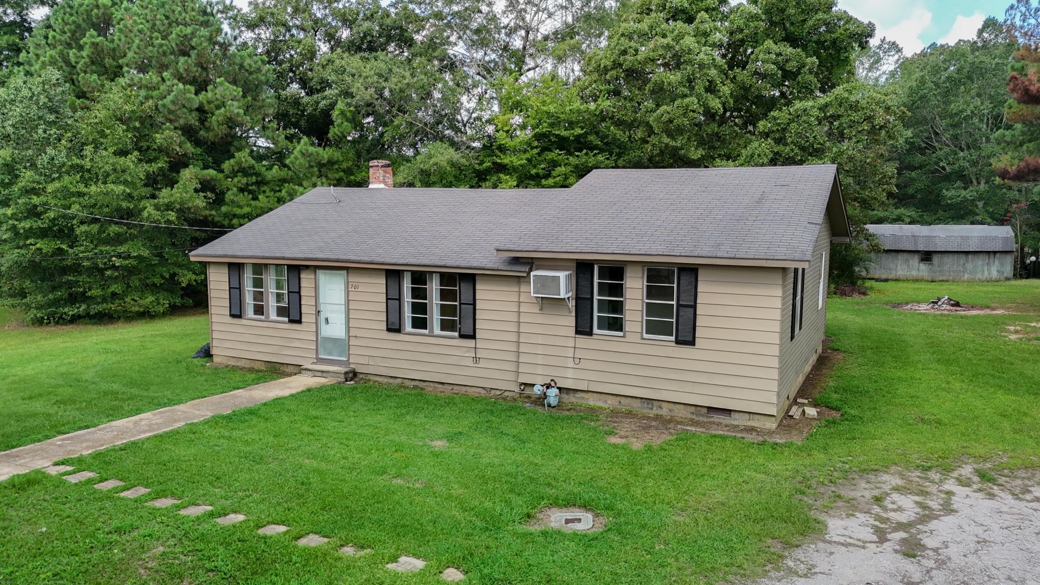 a aerial view of a house next to a yard and brick wall