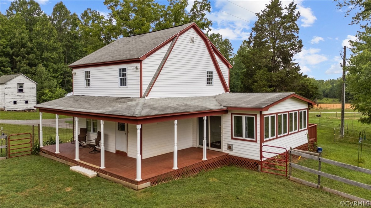 a view of a house with a yard and deck area