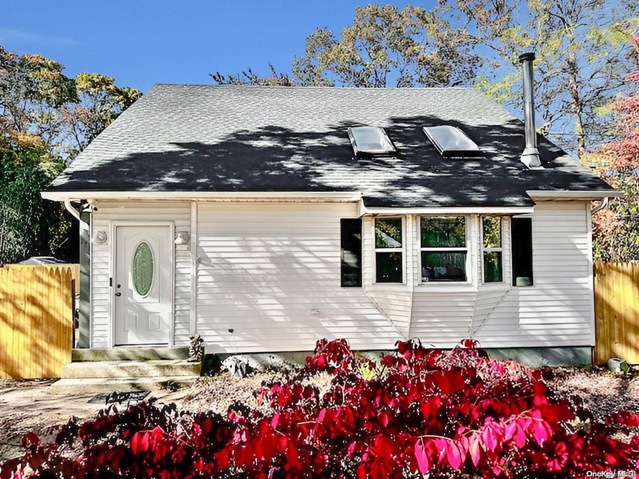 a front view of house with lot of flowers