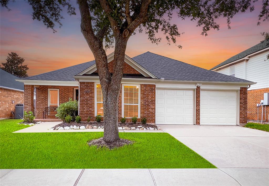 a front view of a house with a yard and green space