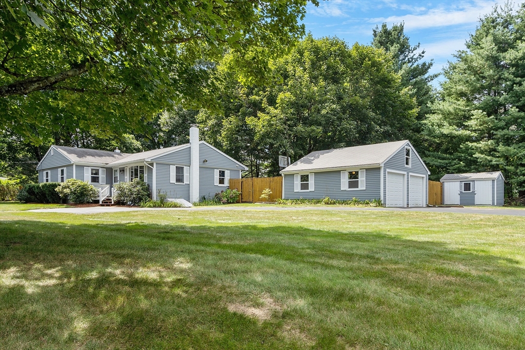 a front view of a house with a yard and trees