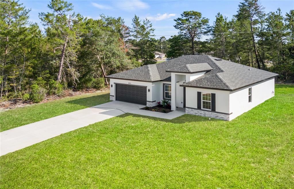 a aerial view of a house with a yard table and chairs