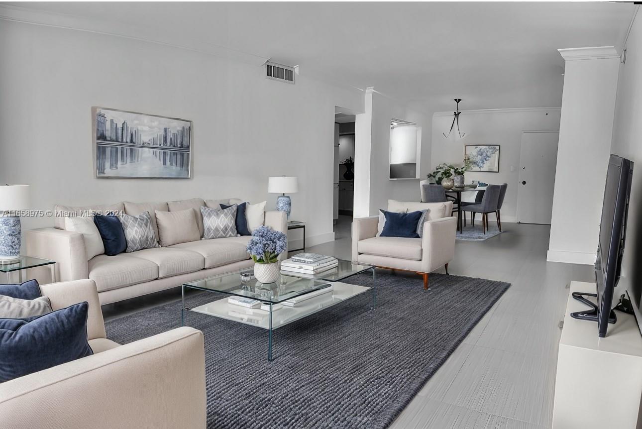 a living room with furniture and a dining table with wooden floor