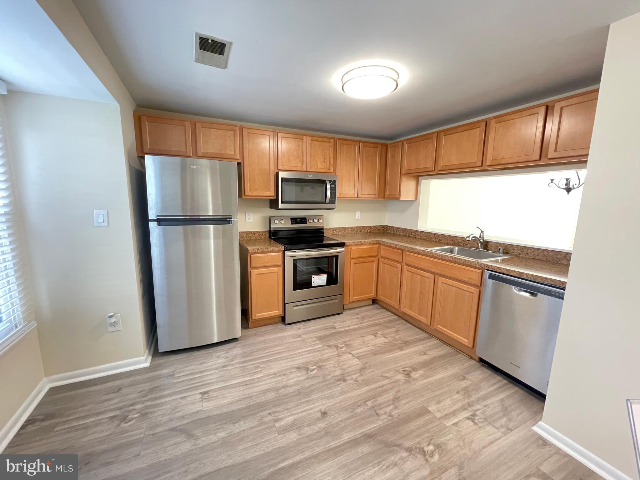 a kitchen with kitchen island a refrigerator sink and cabinets